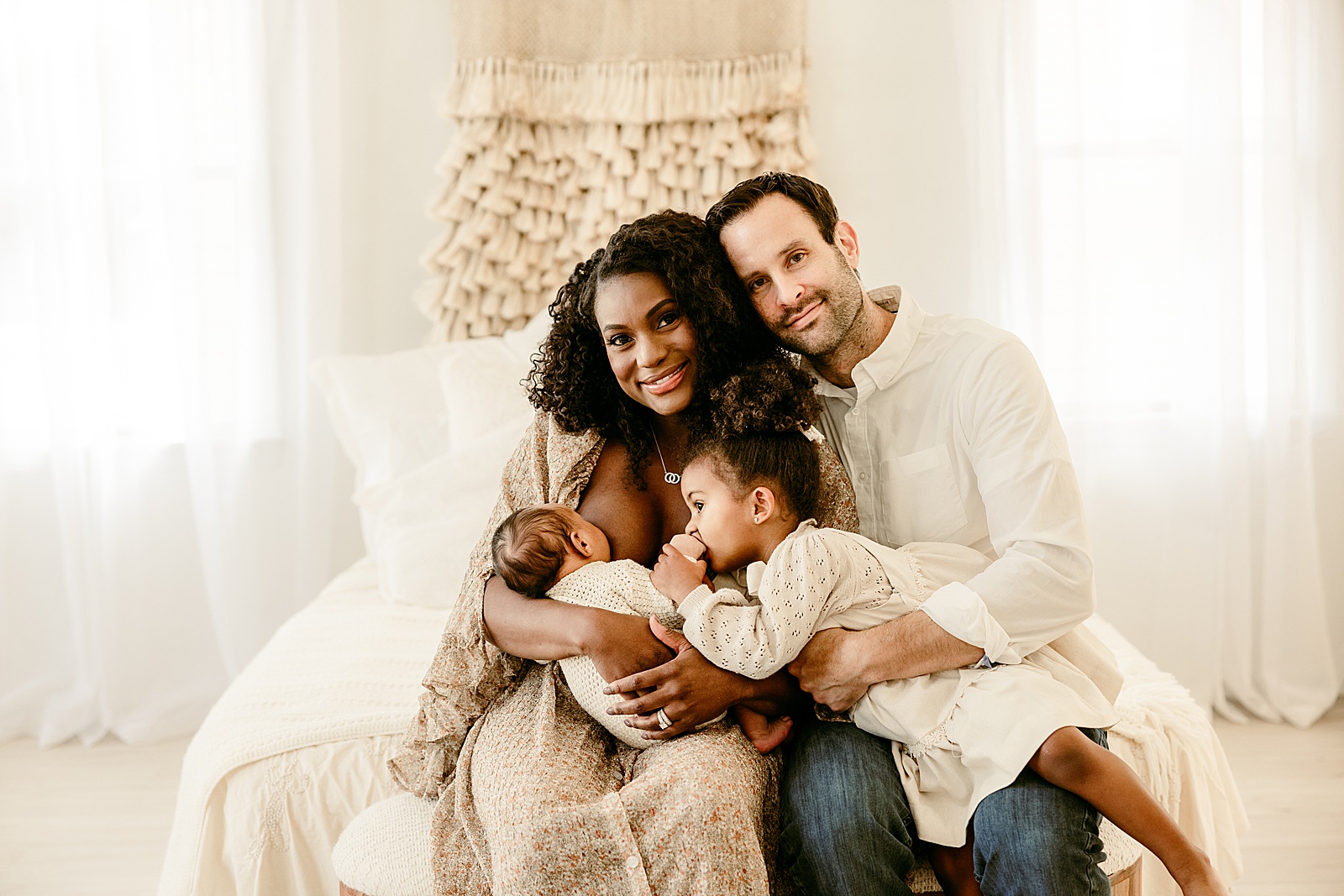 Parents holds young children close together during Lifestyle Newborn Session