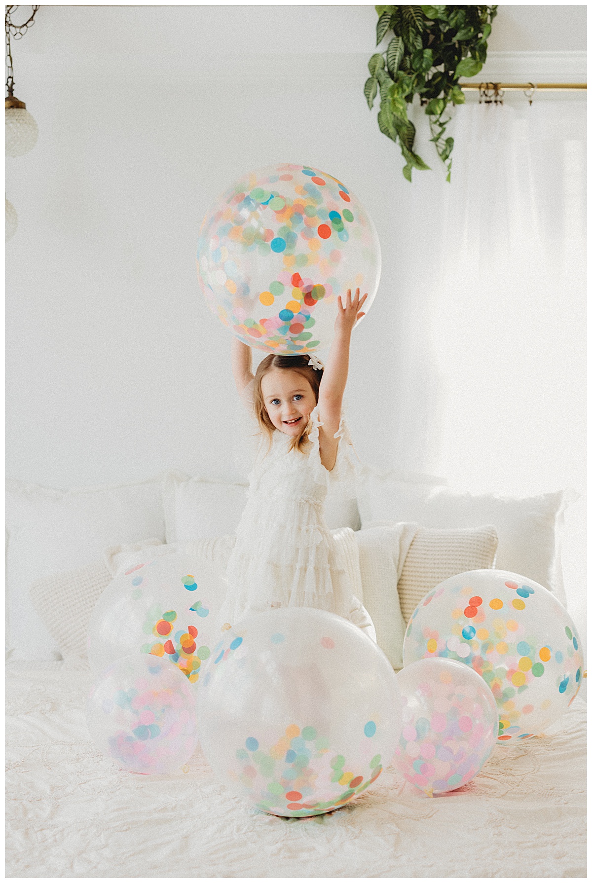 Girl plays with confetti balloons for Norma Fayak Photography
