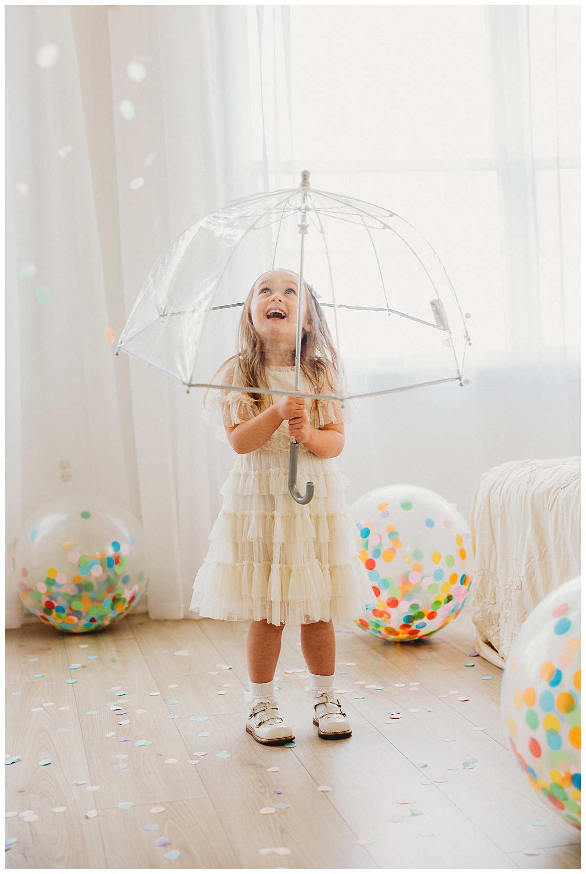 Young girl stands under umbrella during her 3-Year-Old Milestone Session