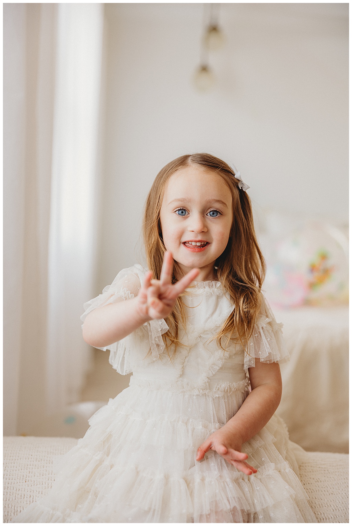 Young girl holds up fingers during her 3-Year-Old Milestone Session