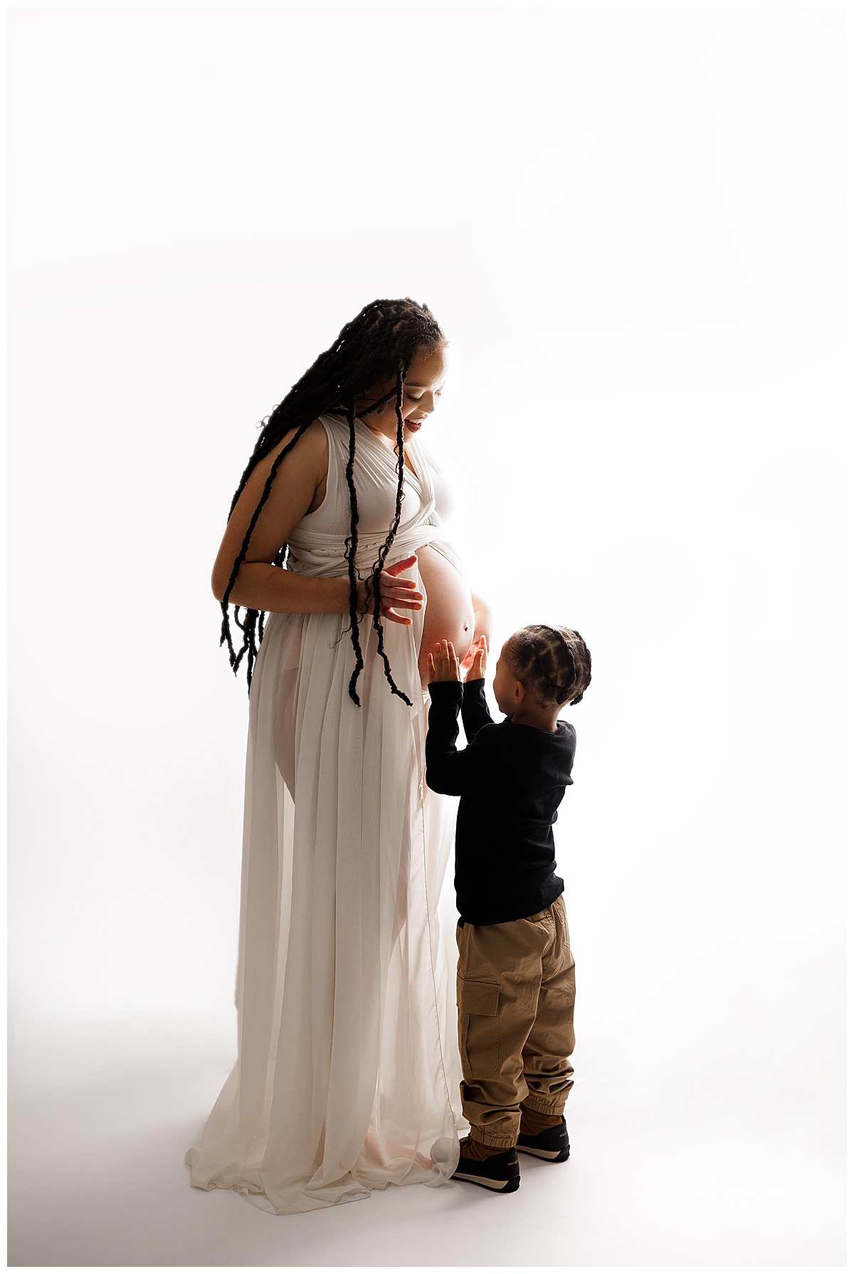 Young child holds mom's baby bump for Norma Fayak Photography